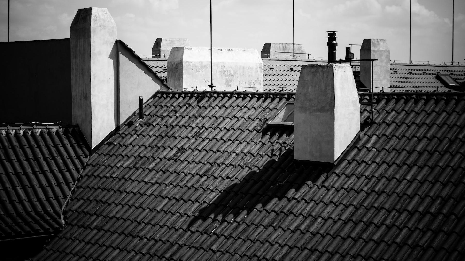 grayscale photography of building under cloudy sky